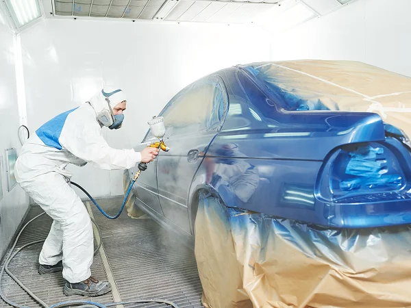 A person is spray-painting a car.