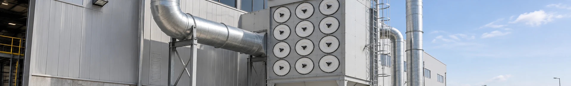 A cartridge dust collector system is installed outside the factory building.