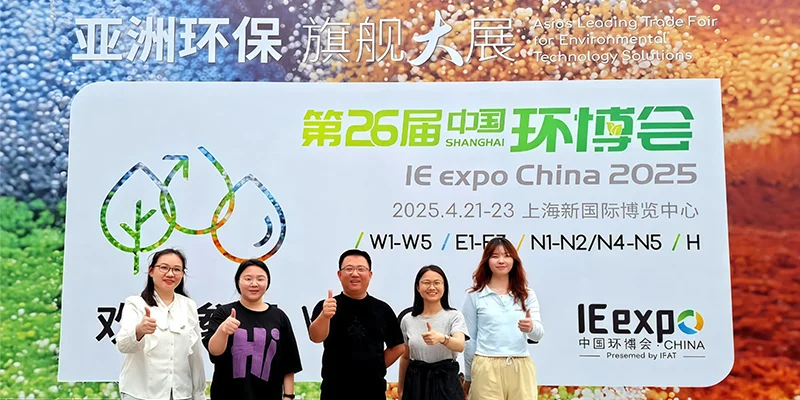 PureFlow employees posing for a group photo in front of the promotional banner