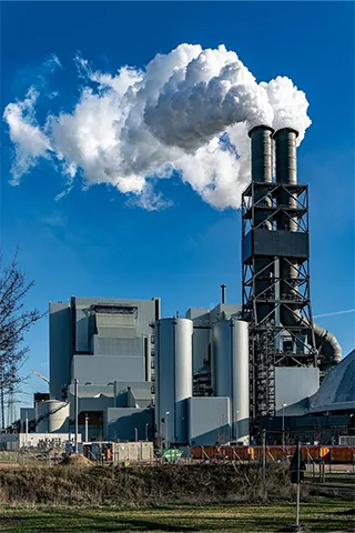 Two factory chimneys emitting smoke