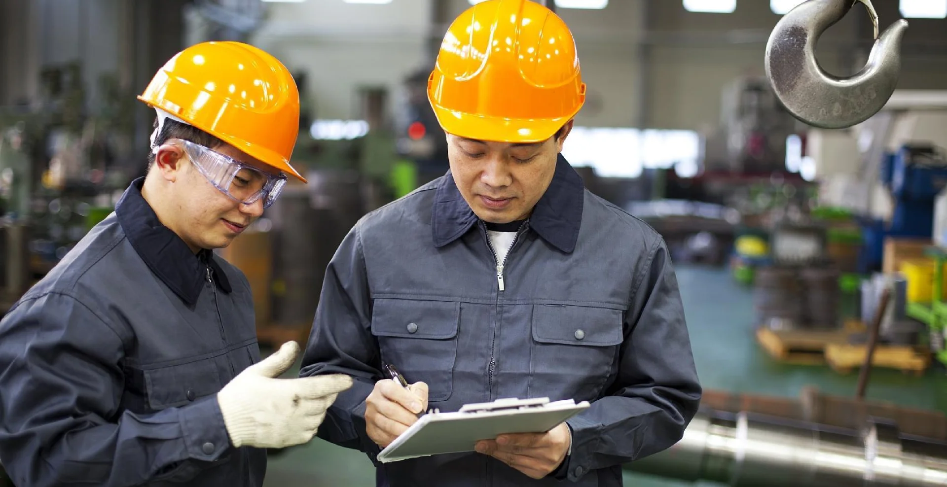 Two engineers wearing safety helmets are communicating.