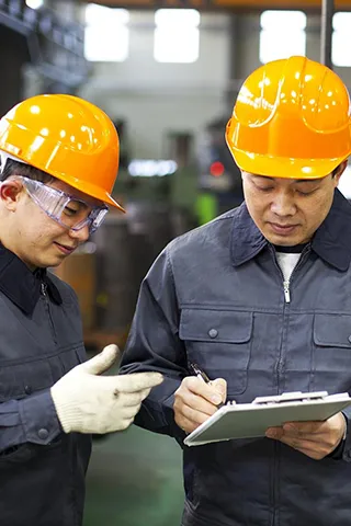 Two workers discussing with paper and pen