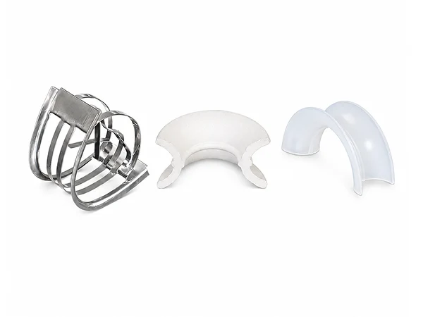 Three Intalox saddle rings of different materials arranged together.